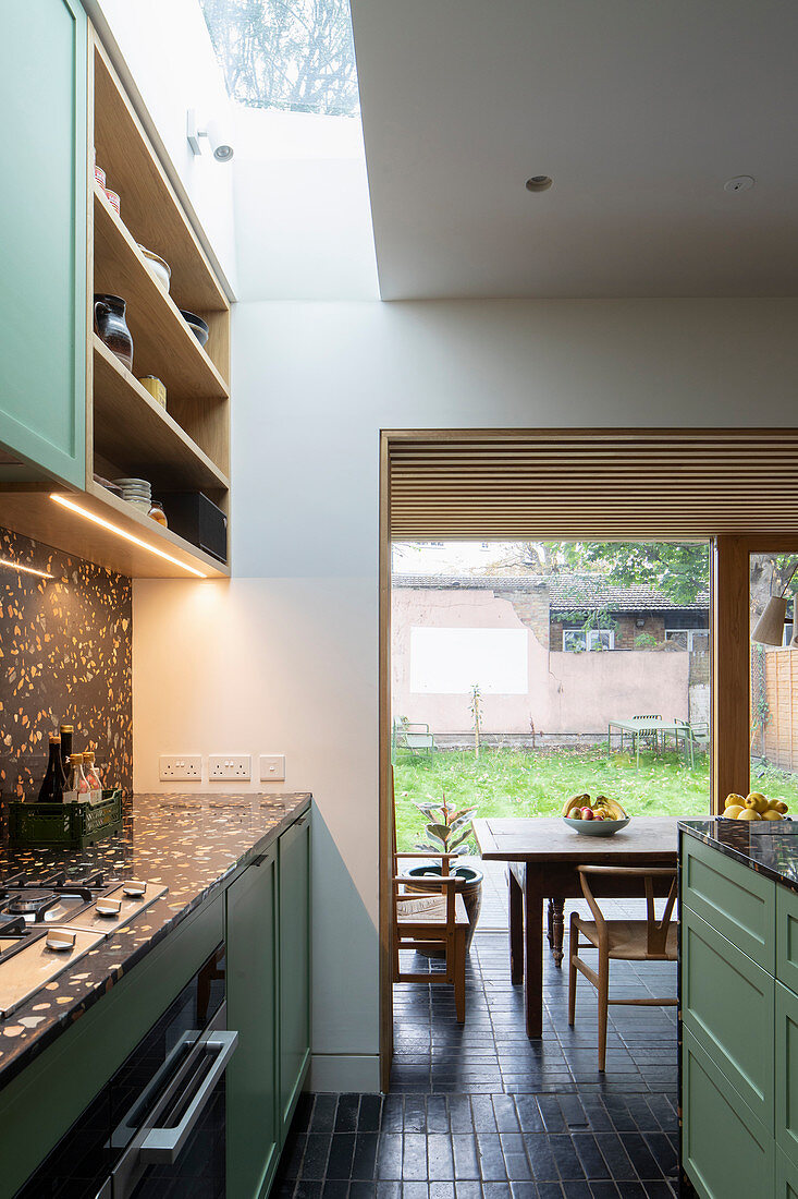 Kitchen with black terrazzo elements, skylight and dining area in extension