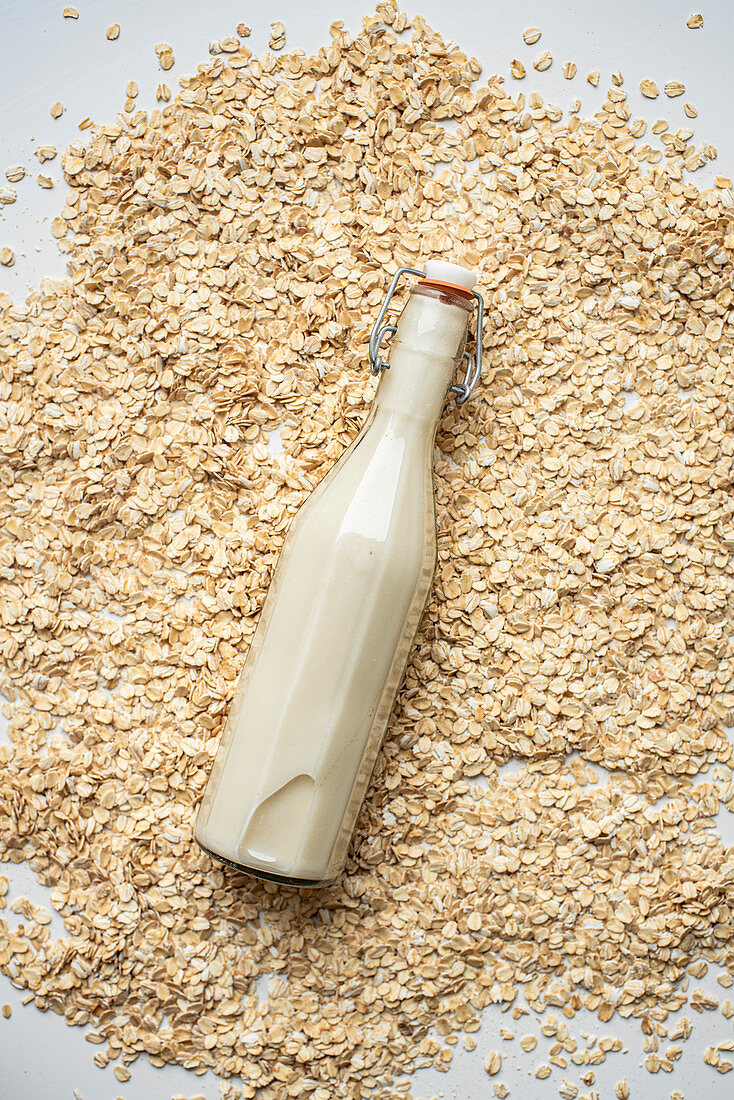 Haferdrink in Flasche auf Haferflocken