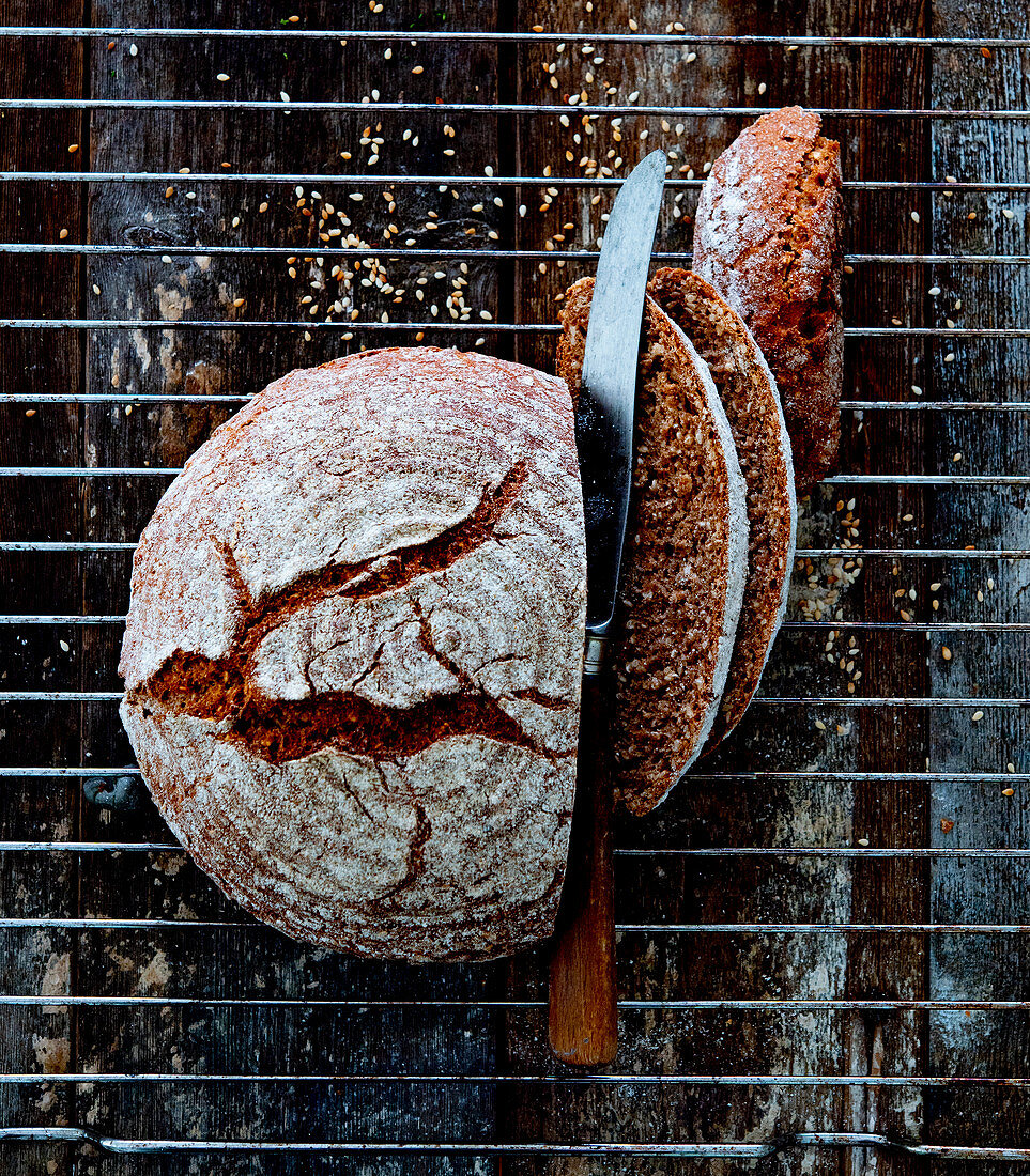 A round loaf of spelt and sesame seed bread, sliced