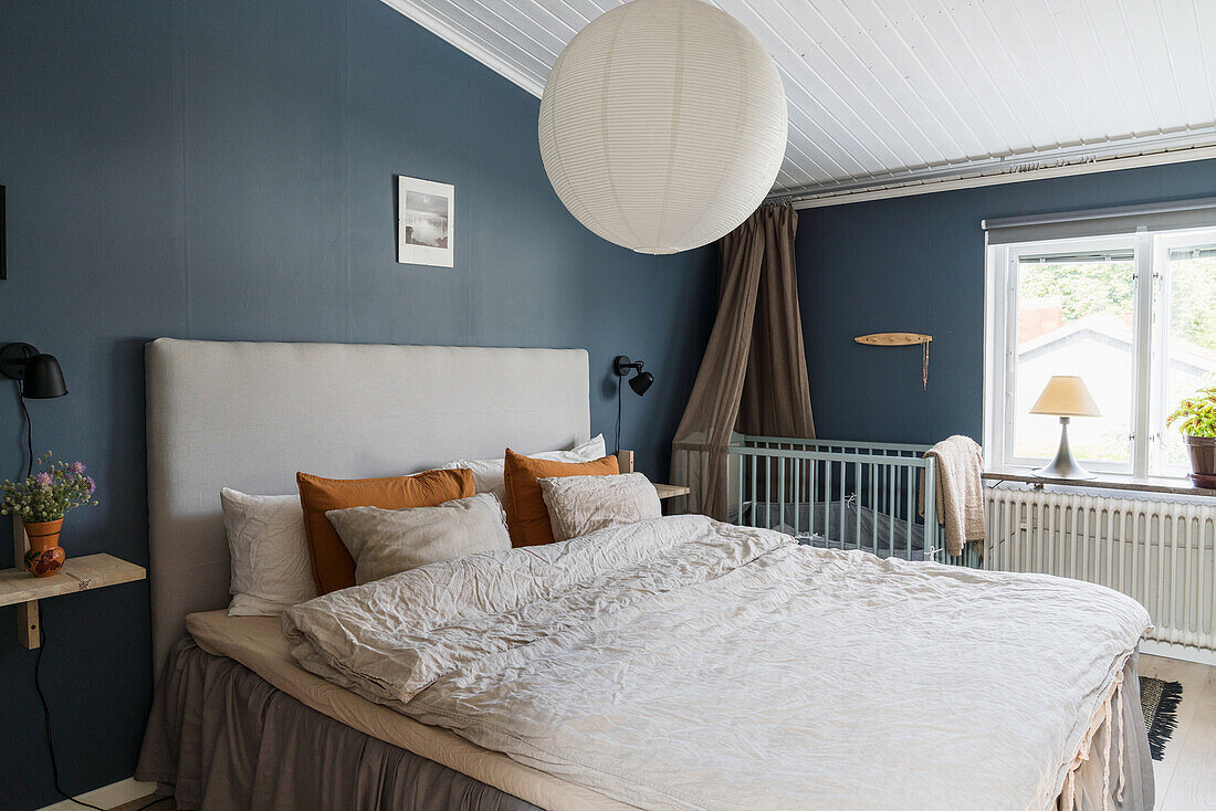 Double bed and cot in bedroom with blue walls