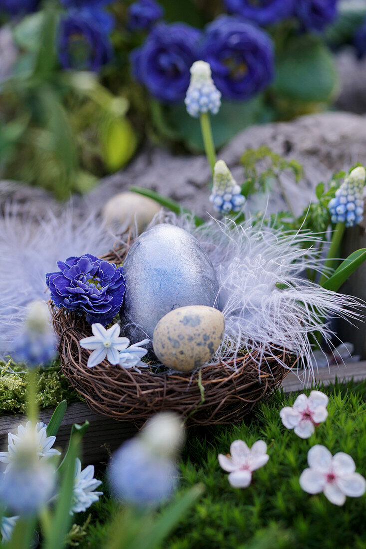 Easter basket with Easter eggs, flowers and feather