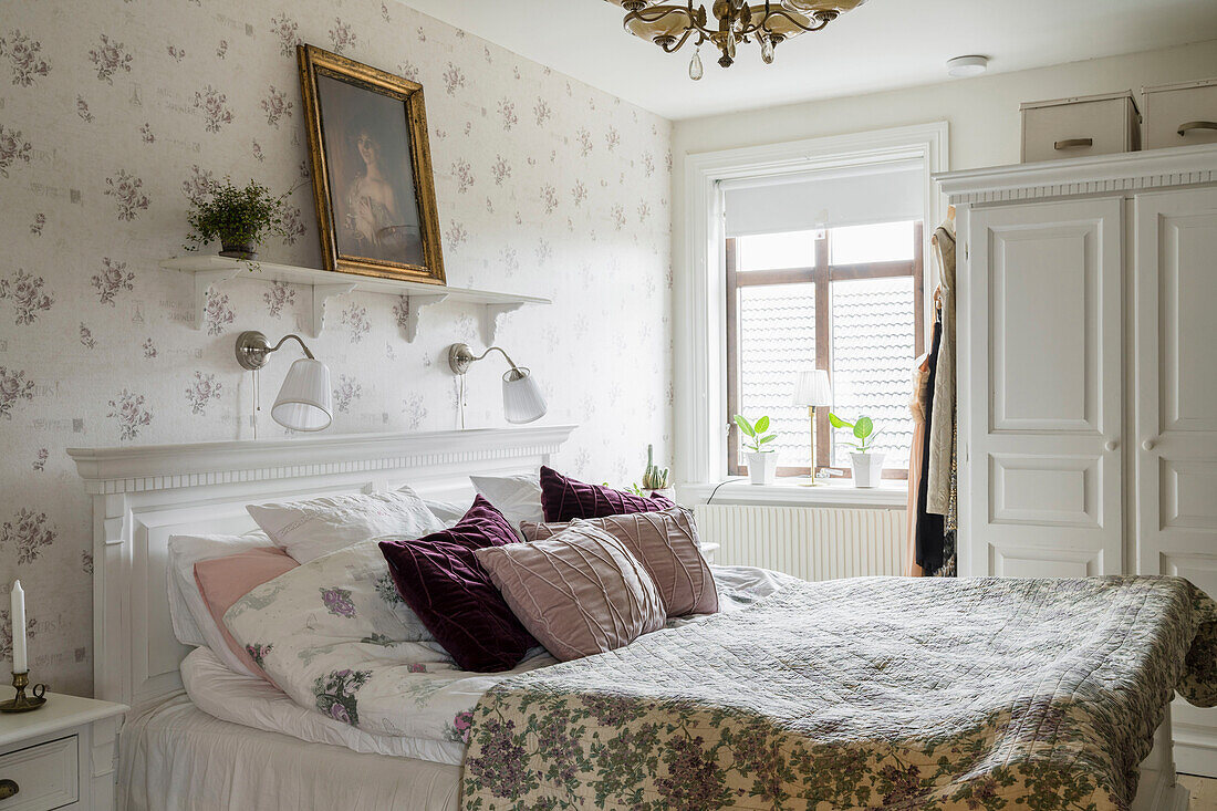 Double bed in the bedroom with romantic wallpaper
