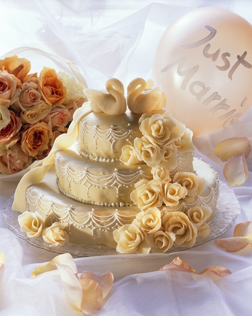 Three-tiered wedding cake with marzipan roses and swans