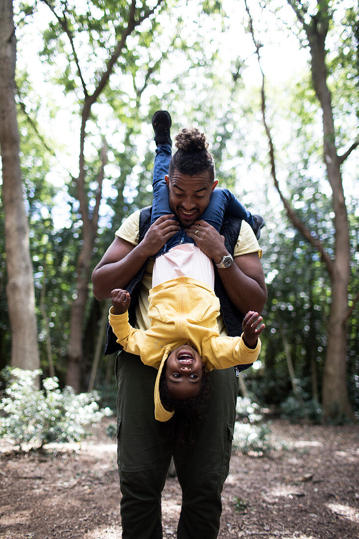 Playful father holding daughter upside down
