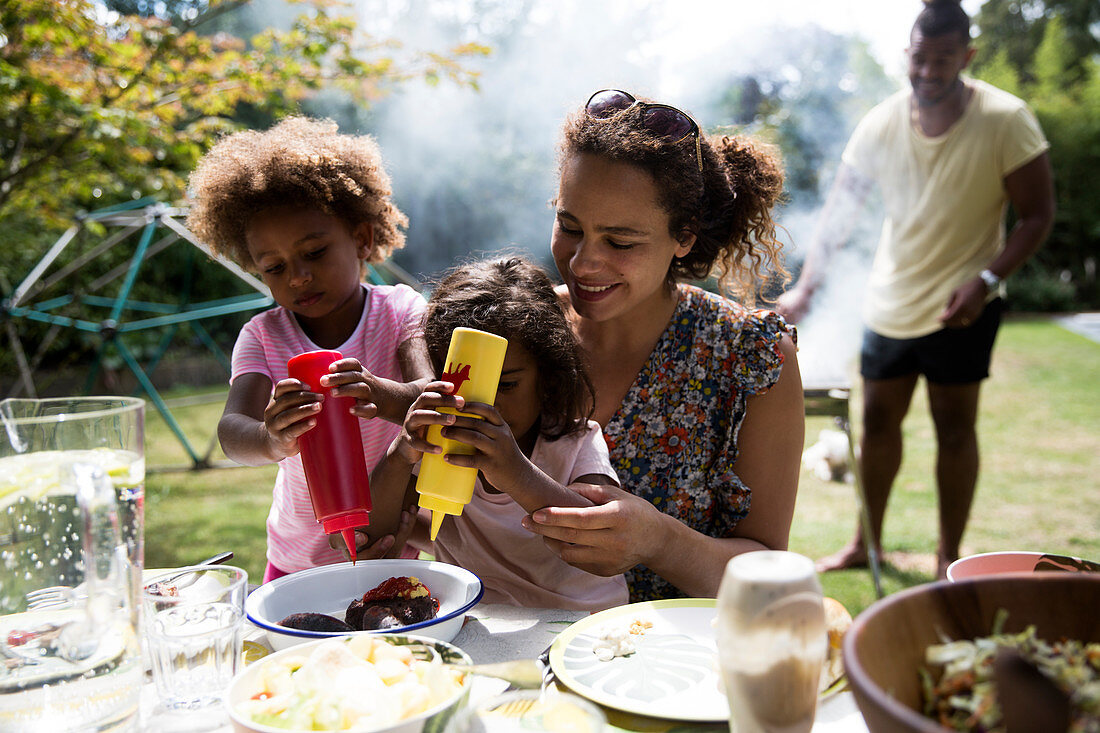 Mother and daughters enjoying barbecue
