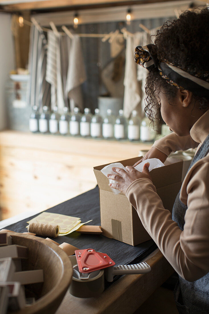 Female shop owner preparing package for shipping