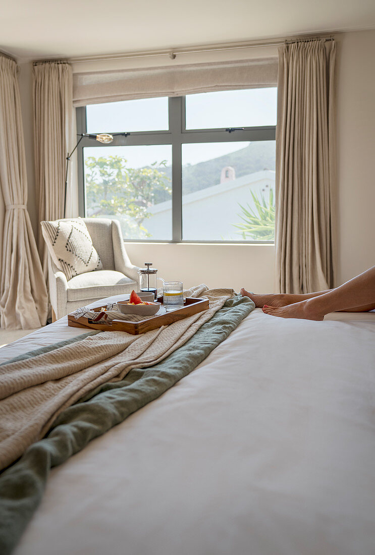 Breakfast tray on bed in sunny morning bedroom