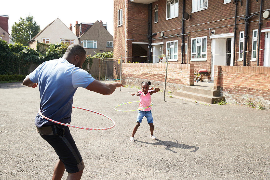 Father and daughter playing with plastic hoops