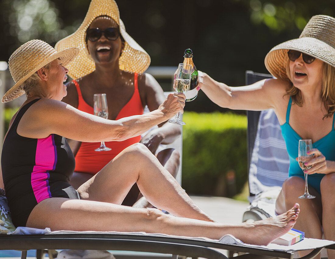 Senior women friends drinking champagne on summer patio