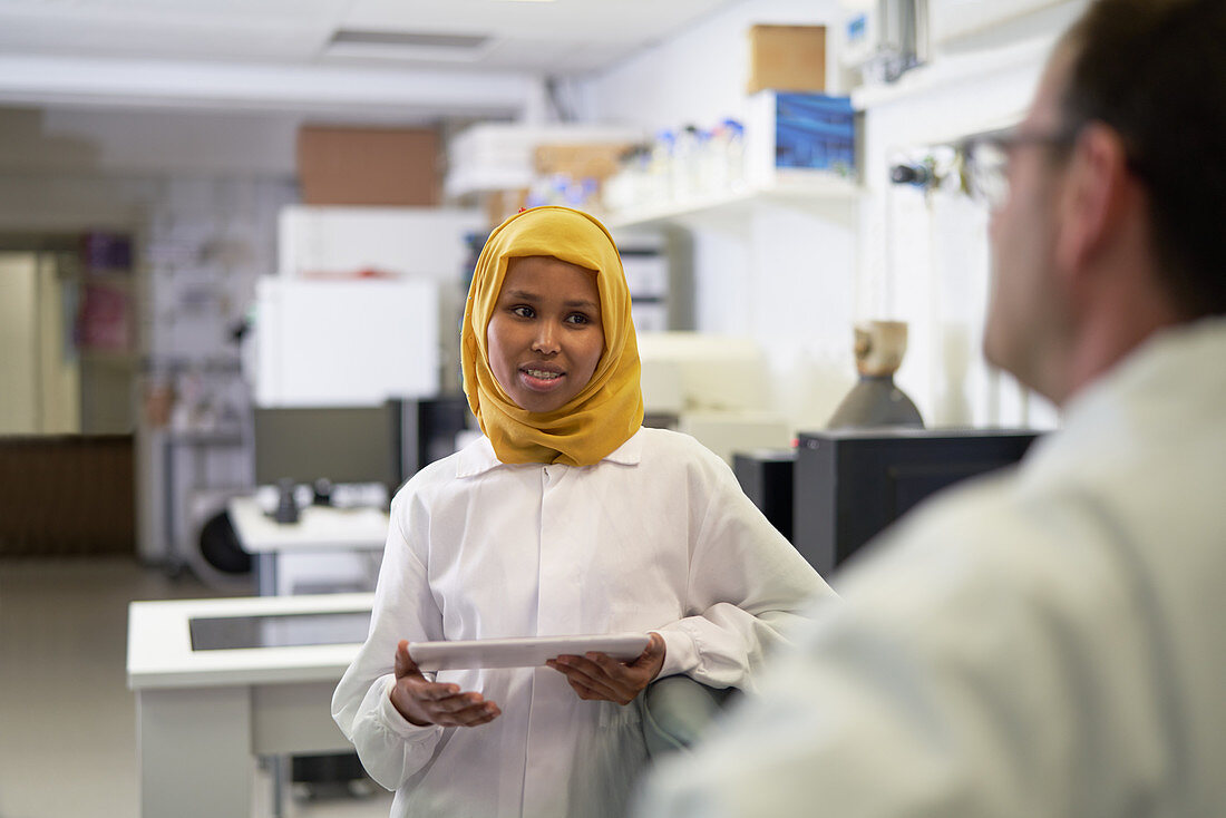 Scientist in hijab talking with colleague
