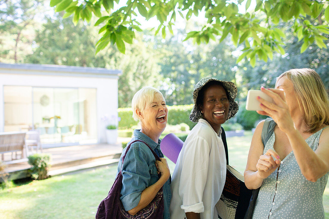 Happy senior women friends taking selfie in garden