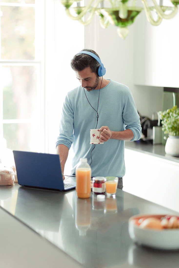 Man with headphones working from home at laptop