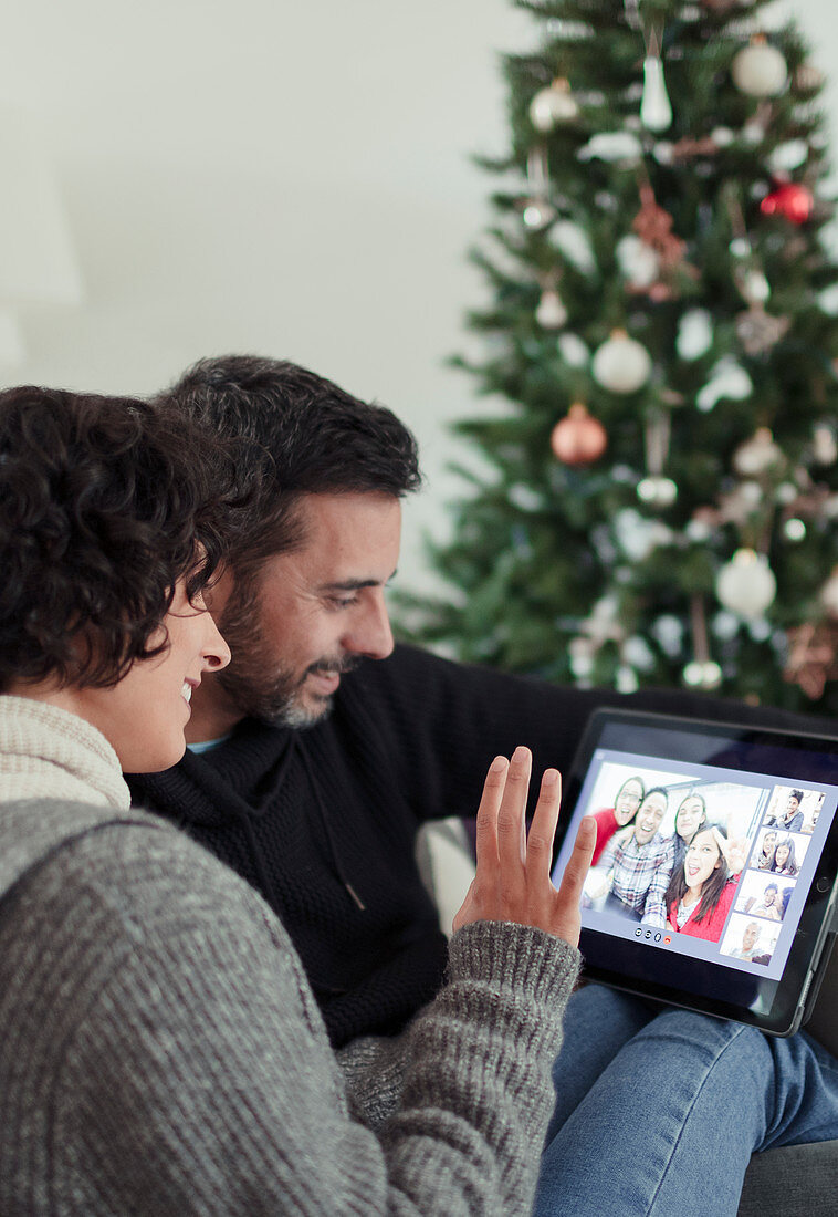 Happy couple video chatting with family at Christmas