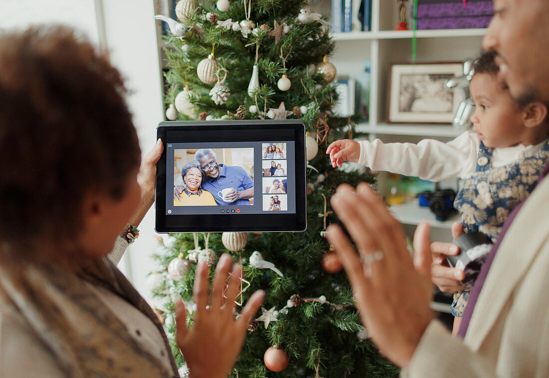 Family video chatting by Christmas tree