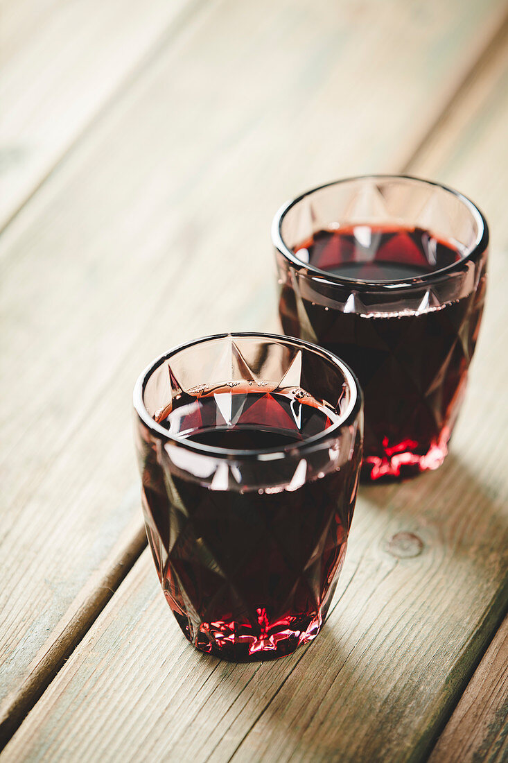 Two glasses of red wine on wooden background