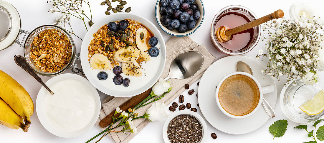 Gesundes Frühstück mit Müsli, Joghurt, Kaffee, Obst und Chiasamen