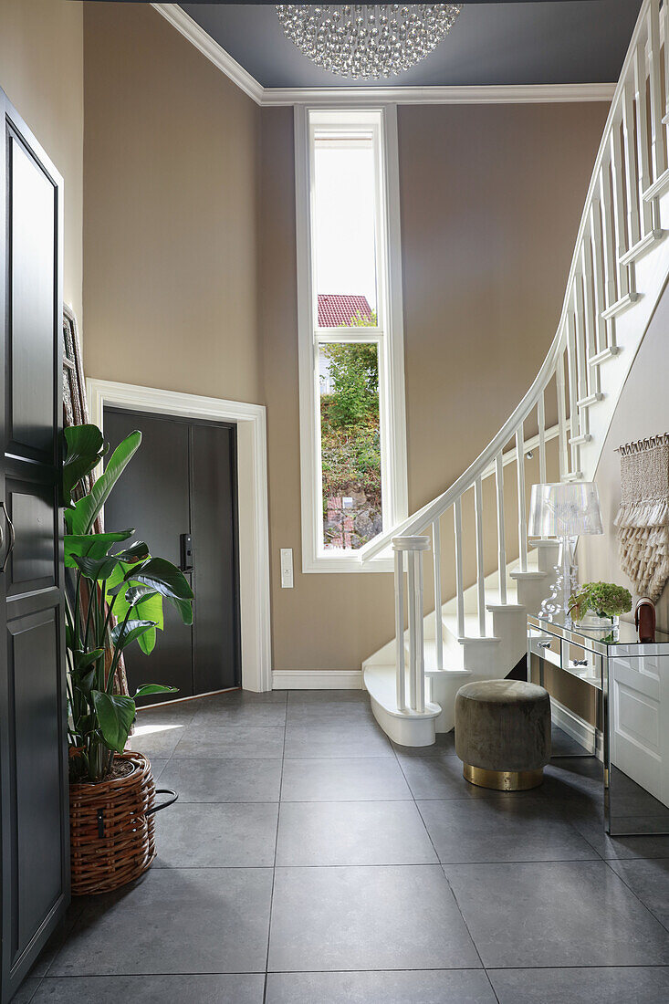 White staircase in high-ceilinged hallway