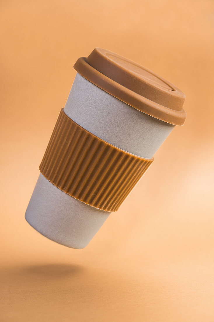 Paper cup of takeaway coffee with brown silicone ring