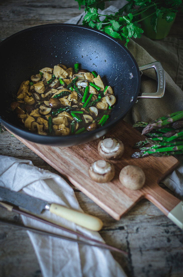 Hühnerfleisch mit Pilzen und Spargel im Wok