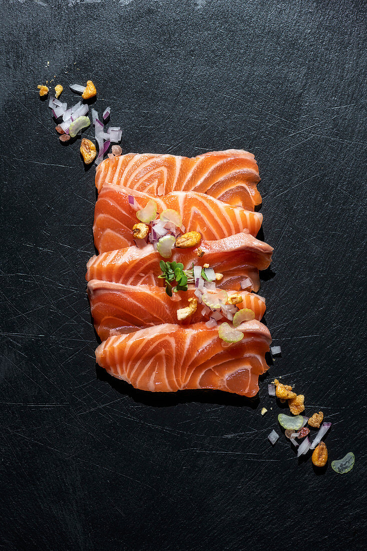 Raw salmon fillet with nuts and onion