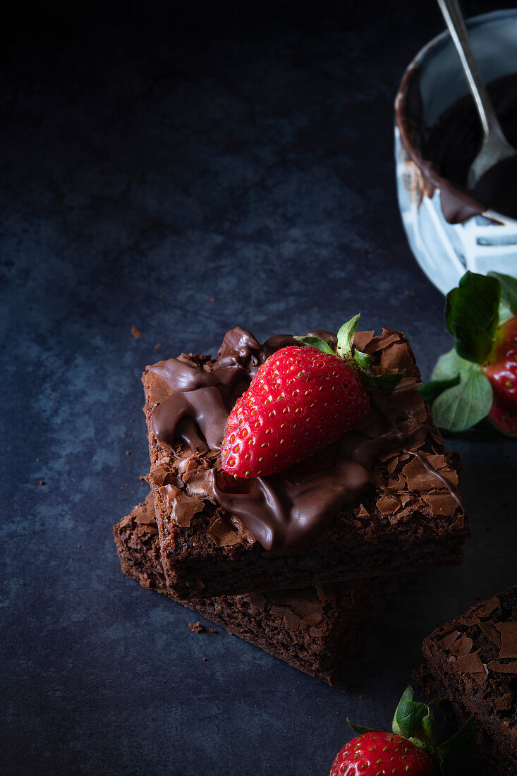 Brownies with melted chocolate and strawberries.