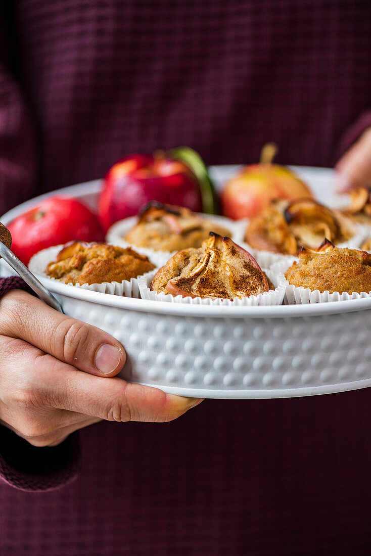 Hände halten Apfel-Zimt-Muffins