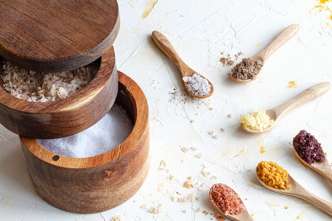 Various types of salt in wooden jars and spoons