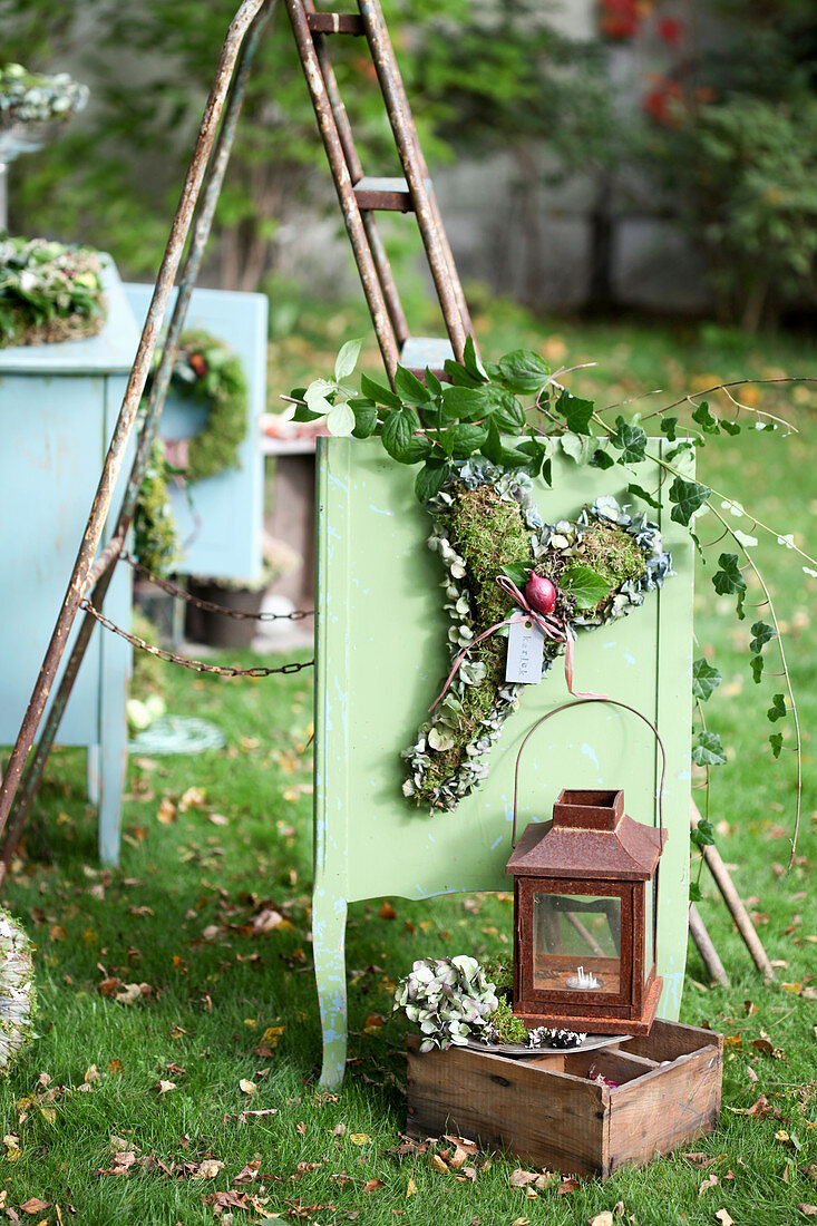 Autumn arrangement with a heart made of moss, hydrangea flowers and onion, lantern and wooden box