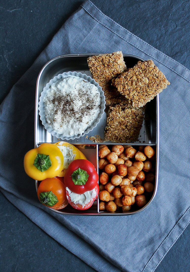 Frühstücksbox mit Müsliriegel, gefüllter Snackpaprika und Kichererbsen