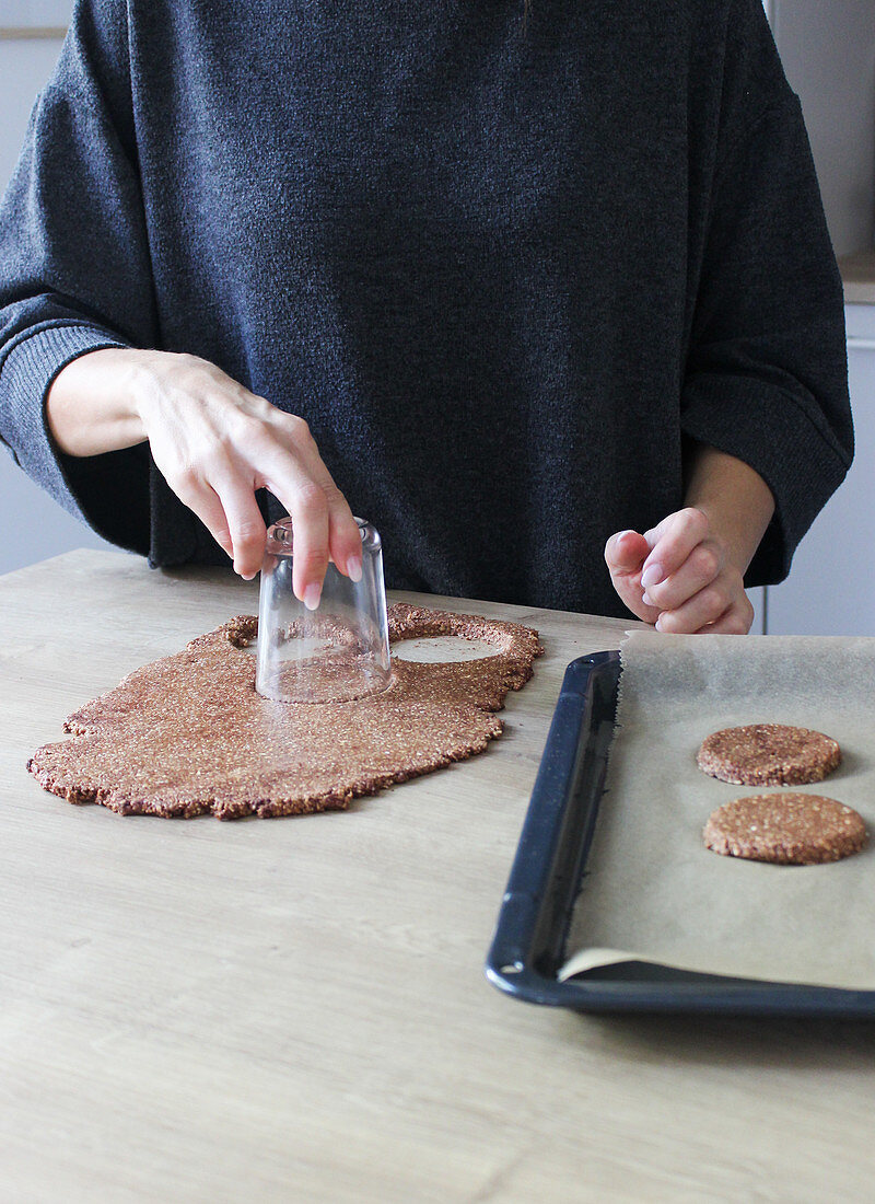 Chocolate biscuits being cut out with a glass