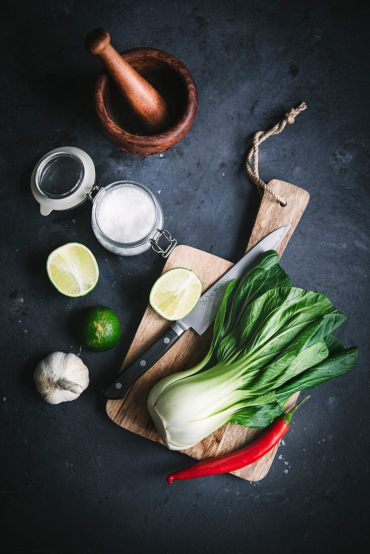 Stilleben mit Pak Choi, Limetten, Knoblauch und Chilischote