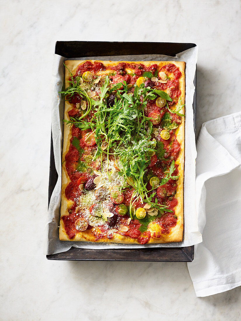 Vegan wholemeal pizza with tomatoes and rocket salad