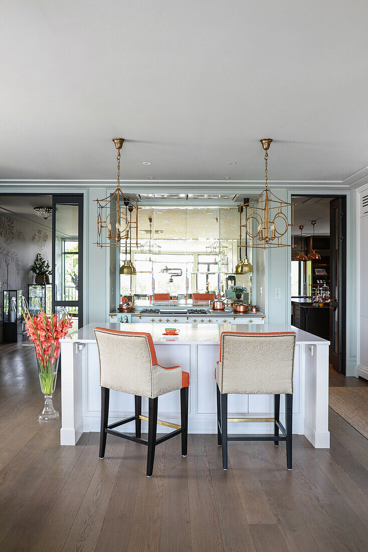 White island counter and designer chairs in open-plan kitchen