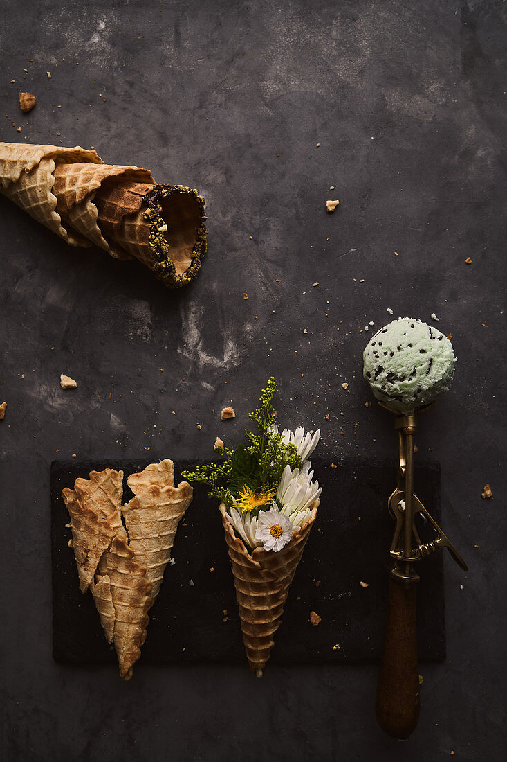Green ice cream scoop and waffle cone with flowers