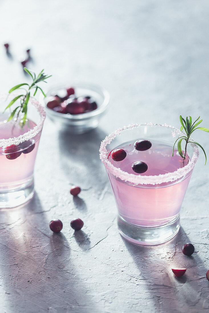 Cranberrydrink mit Rosmarin in Gläsern