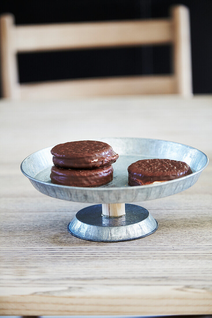 A homemade cake stand made from zinc plates and a wooden stick