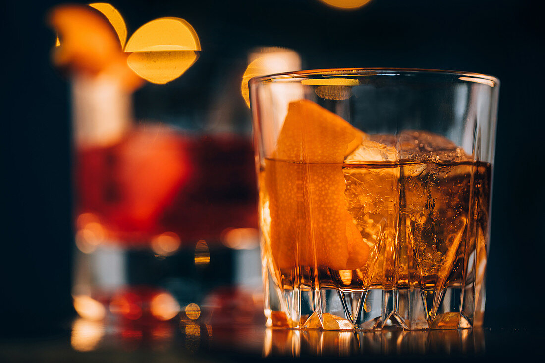 Old Fashioned Cocktail mit Orangenschale und Eiswürfeln
