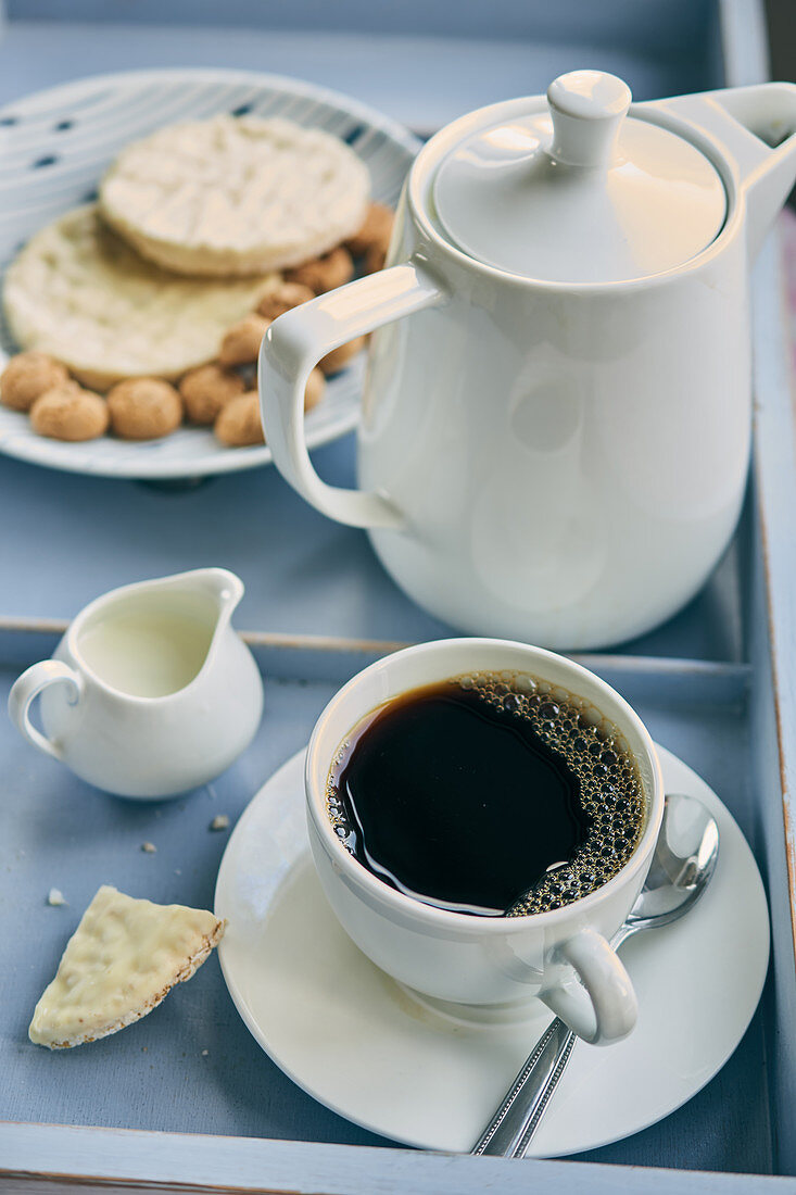 Eine Tasse mit Filterkaffee dazu Kekse und Gebäck