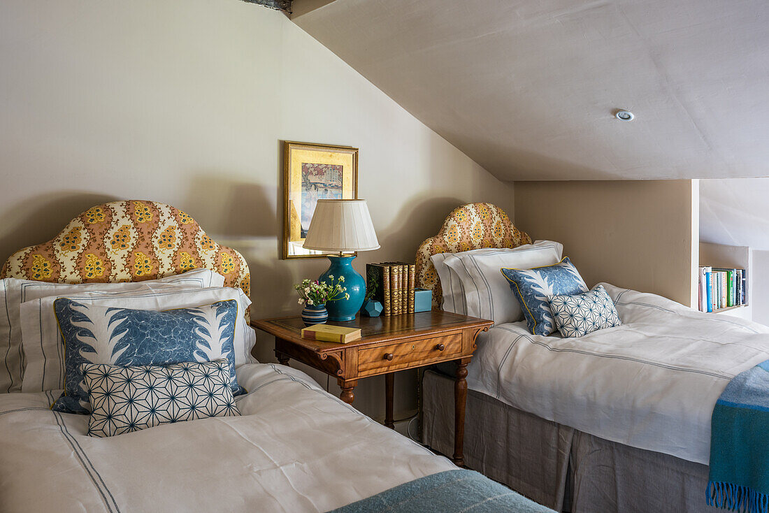 Twin beds with bedside table in attic guest bedroom