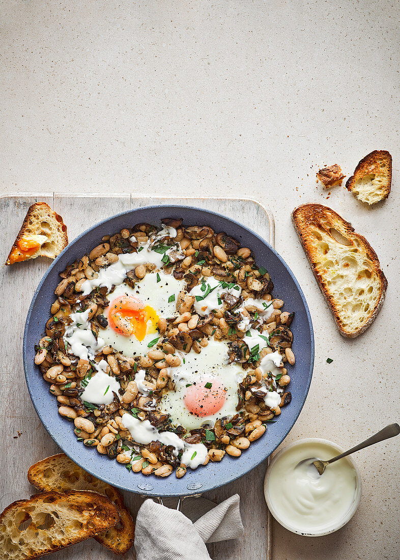 Baked eggs with beans, mushrooms, tarragon and crème fraîche