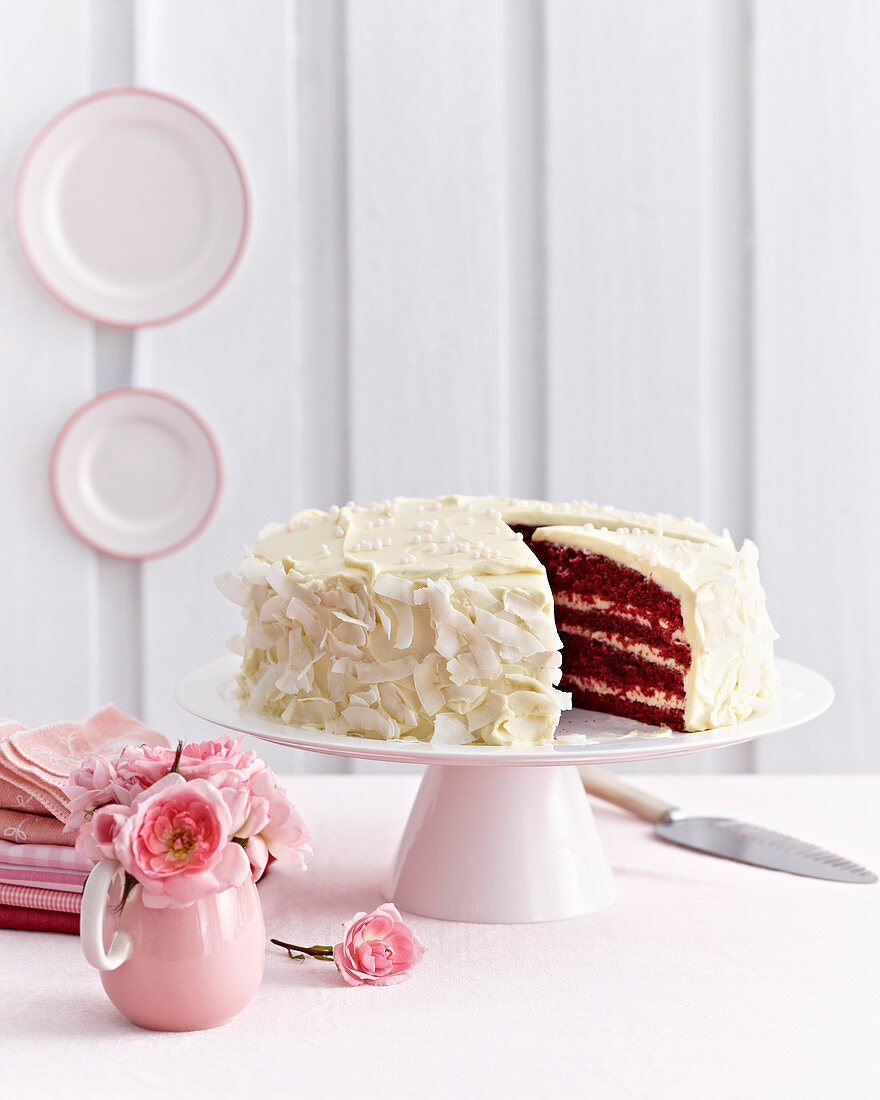 Pink-Velvet-Cake mit weißer Creme und Kokosspänen, angeschnitten