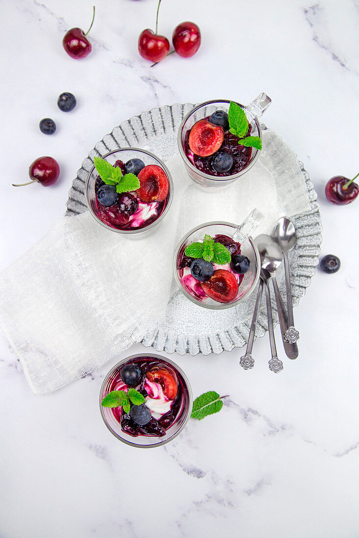 Small glasses with mascarpone cream and egg-free cream with cherries and blackberries