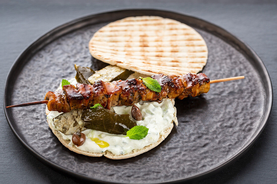 Greek pita bread filled with meat skewer and tzatziki