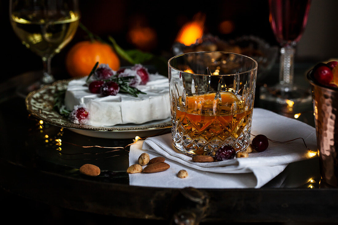 Glasses of bourbon with orange slices, cranberry cocktails, white wine, with oranges, brie with sugared rosemary and cranberries