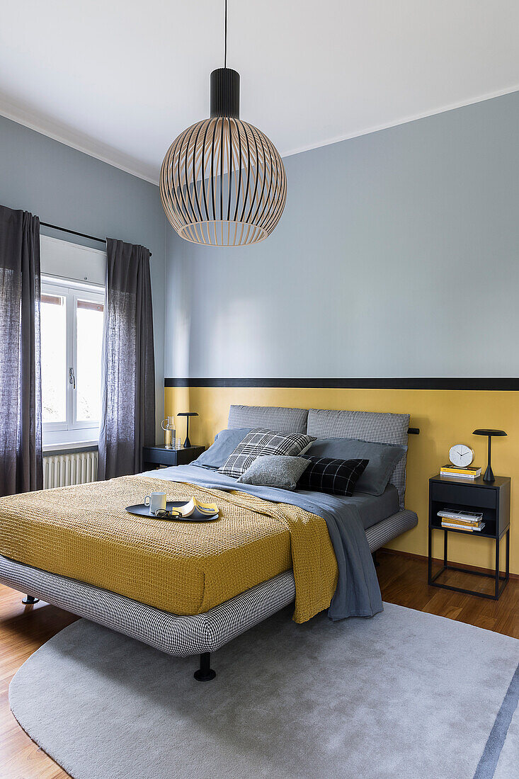 Double bed with grey bed headboard and yellow bedspread