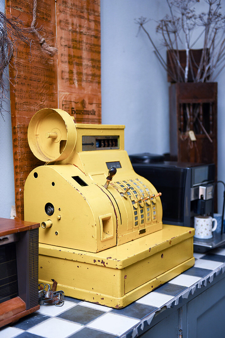 Old, yellow, metal cash register used as vintage decoration