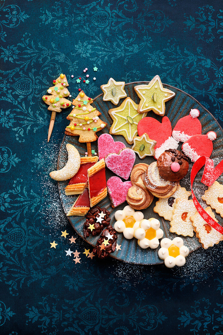 Various colourful Christmas biscuits on plate