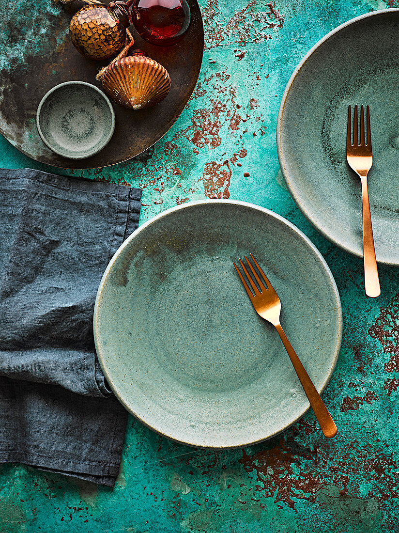 Green ceramic plates and golden forks (for Christmas)