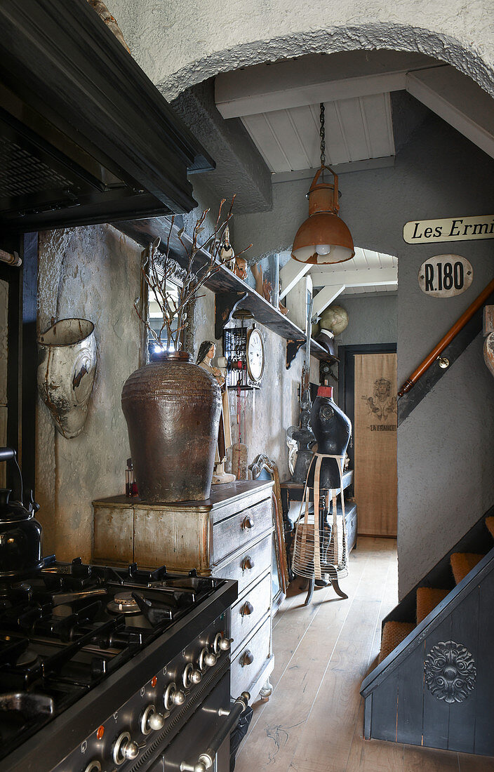 Blick von der Küche mit Gasherd in den Flur mit Trödel und Vintage-Deko