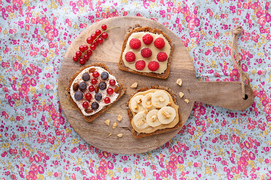 A trio of sweet spreads on bread with fruit